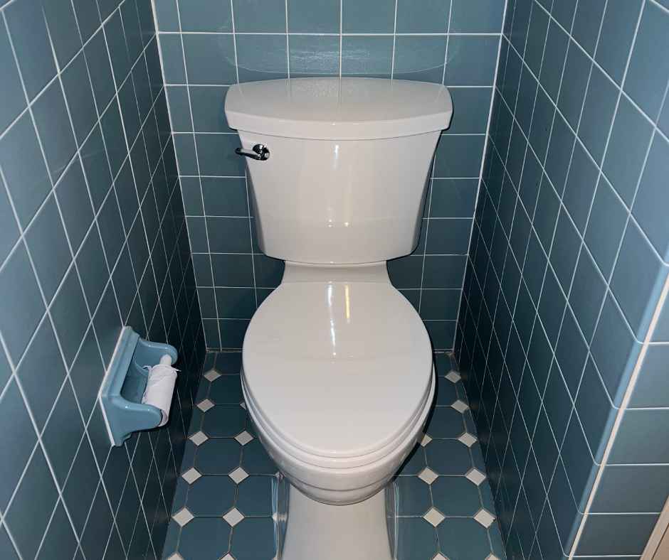 Toilet in the corner of a tiled bathroom